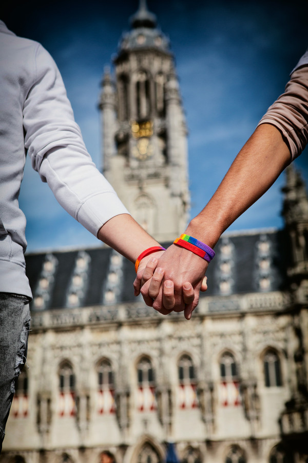 Twee mensen houden handen vast voor het oude stadhuis van Middelburg.